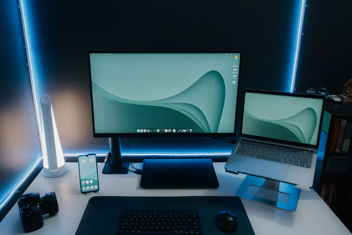 Monitor and laptop on an illuminated desk