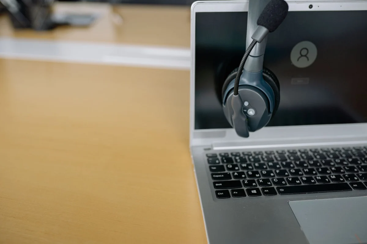 Headphones beside an open laptop