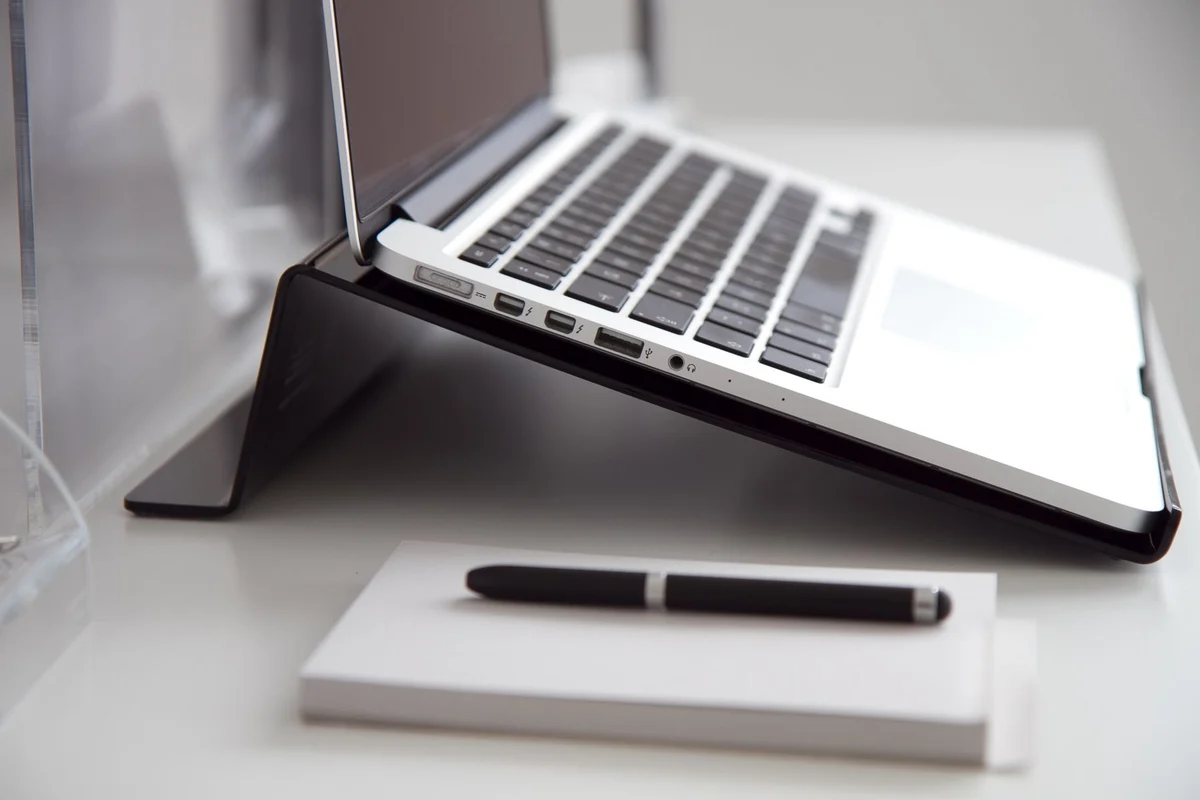 Notebook and pen in front of a laptop