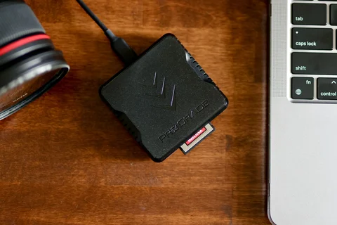 Memory card reader beside a camera and laptop