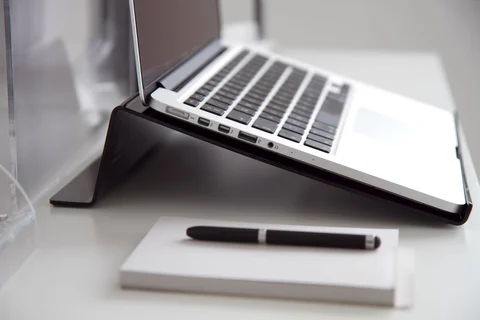 Notebook and pen in front of a laptop