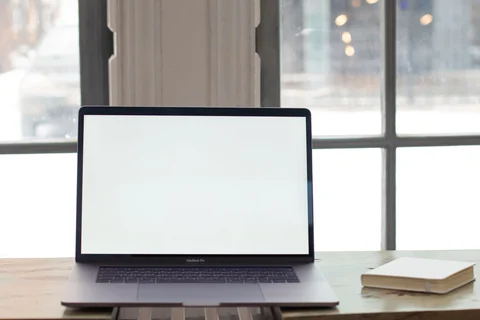 Laptop at a workspace beside a window
